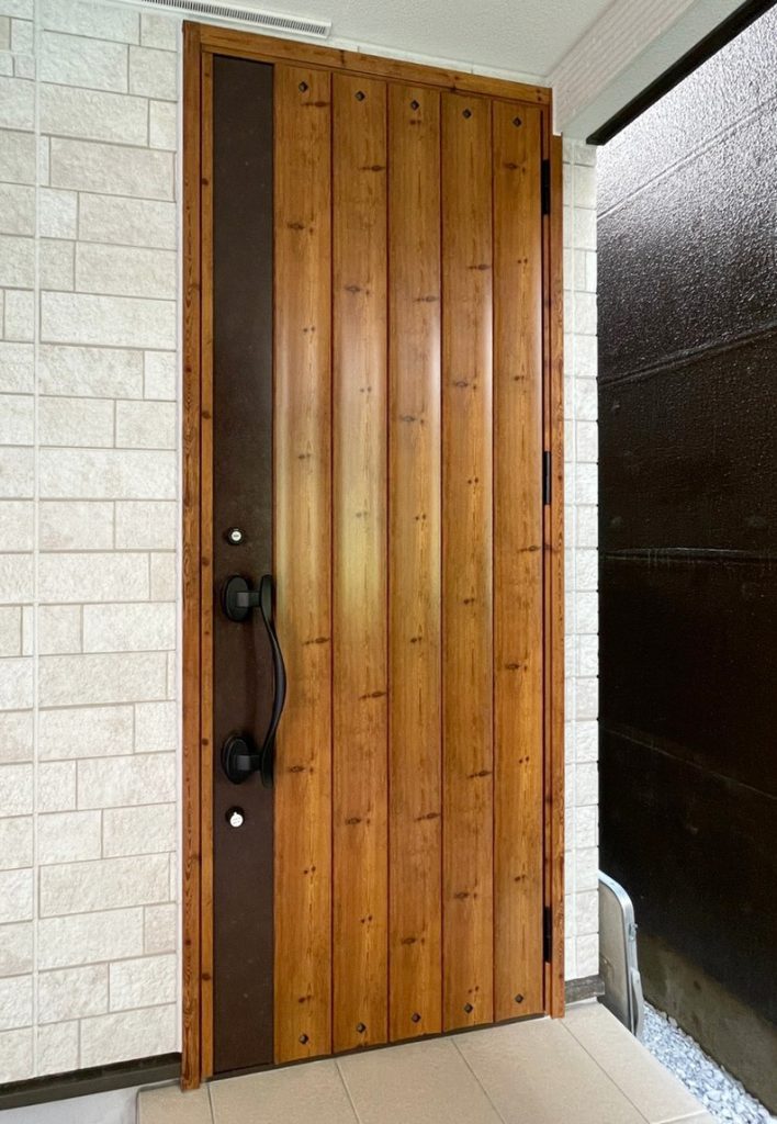 画像：タイル調の外観と木柄の玄関ドアが印象的なエントランス