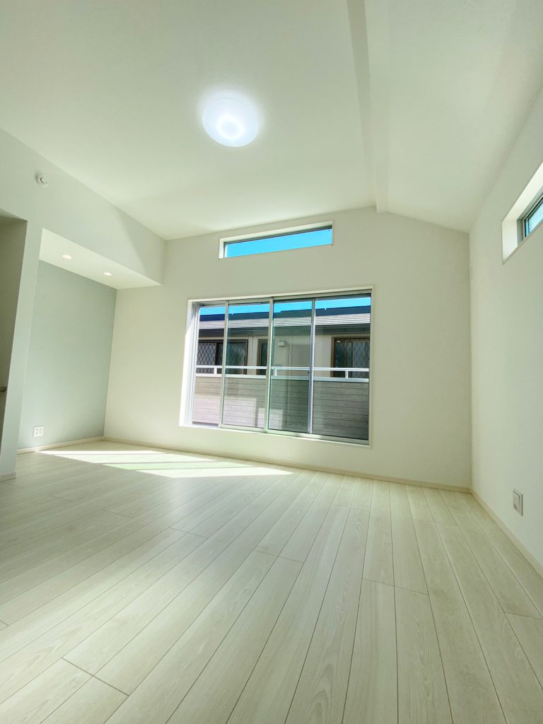 画像：家具を選ばないナチュラルな色合いのフローリング。天井が高く、広がりと開放感を感じる明るいリビングです。